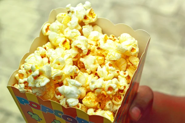 Kind houden popcorn bonbons van witte chocolade bekleed — Stockfoto