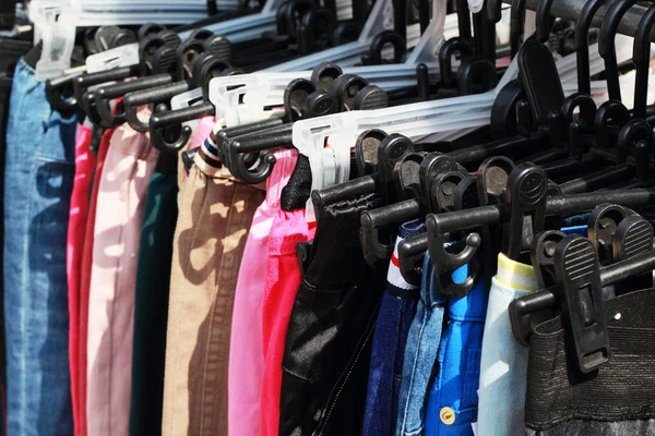 Obchod kalhoty visící na trh stojanu. — Stock fotografie