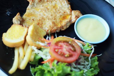 domuz biftek tabakta sebze salatası ile.