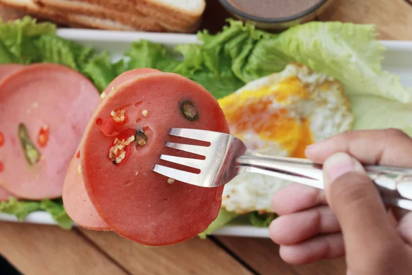 Ham cut into circular discs with red peppers and egg fried. — Stock Photo, Image