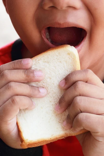 Ребенок ест вкусный кусок хлеба — стоковое фото