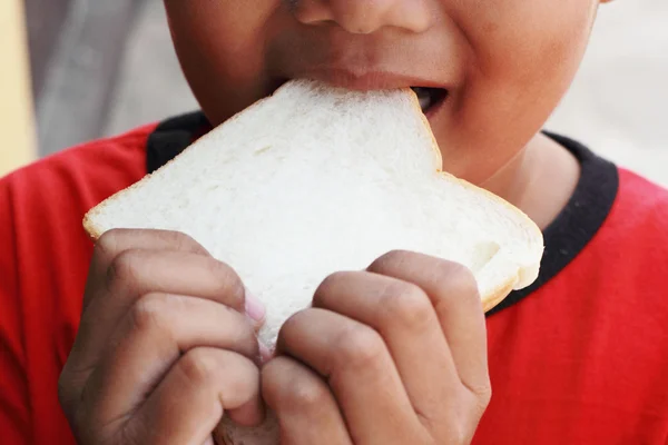 Ребенок ест вкусный кусок хлеба — стоковое фото