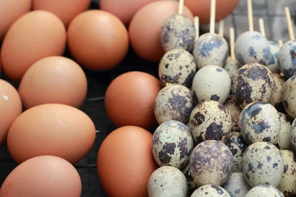 Chicken and quail eggs on the grill. — Stock Photo, Image
