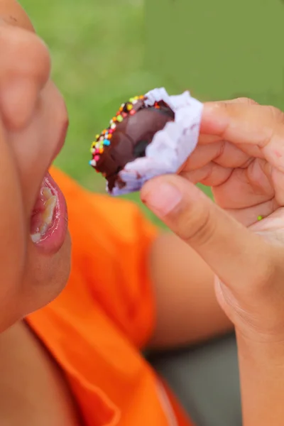 Ребенок ест шоколадный шарик — стоковое фото