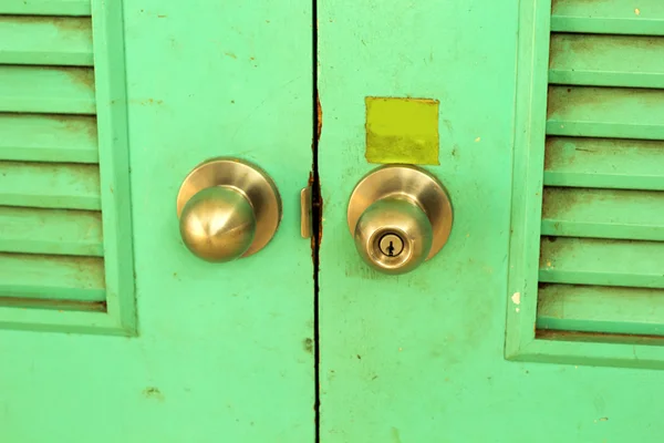 Dveře knoflíky se zeleným pozadím starého dřeva - vintage styl. — Stock fotografie