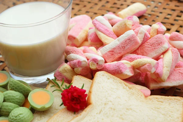 Leche fresca y malvaviscos rosados con una rebanada de pan . — Foto de Stock