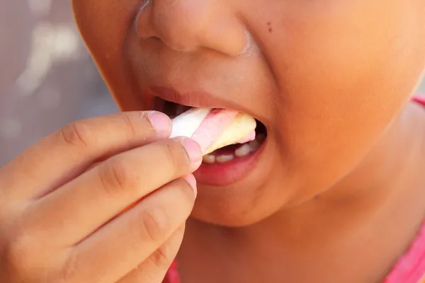 Child eating a marshmallow pink. — Stock Photo, Image
