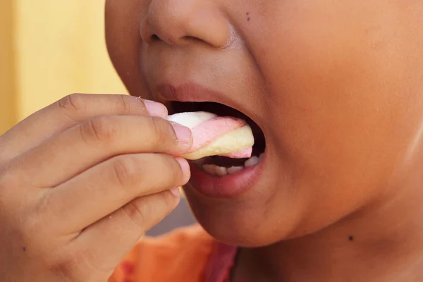 Child eating a marshmallow pink. — Stock Photo, Image