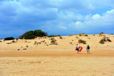 Yüzücüler ve Sampieri Ragusa İtalya 'nın uzun kumlu plajı.