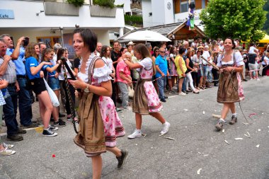 8 Temmuz 2018 San Pietro Val di Funes İtalya, Güney Tyrolean kıyafet köyü festivalinde kırbaç şaklatan genç kadınlar
