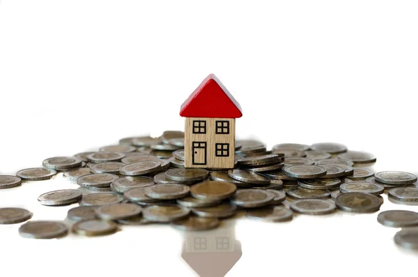 Coins and house standing on it — Stock Photo, Image