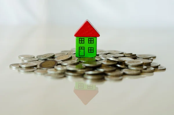 Coins and house standing on it — Stock Photo, Image