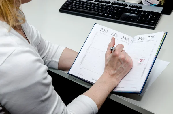 Hand met pen en agenda — Stockfoto