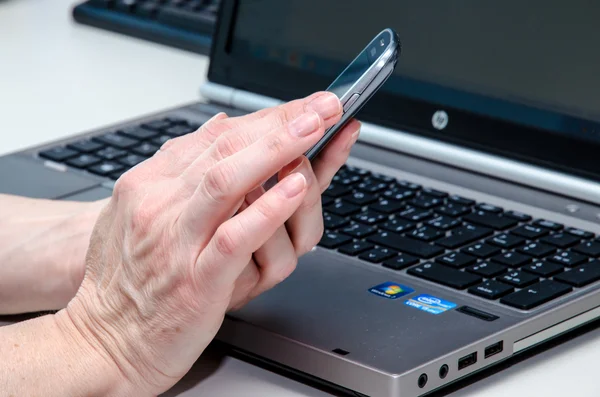 Hand with mobile and notebook — Stock Photo, Image