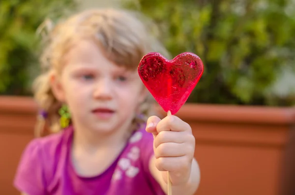 Child with heart lollipop — Stock Photo, Image