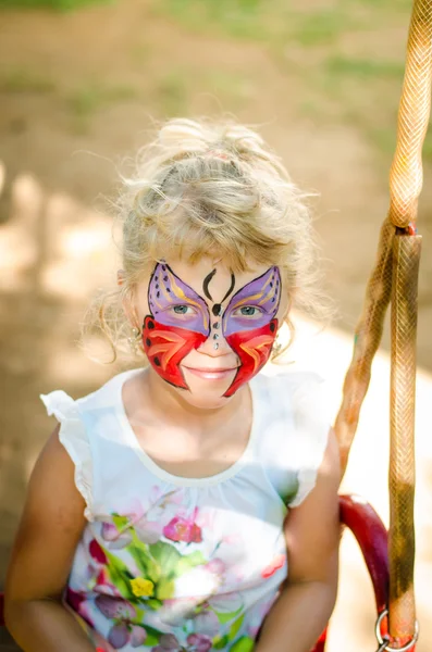 Flicka med fjäril ansiktsmålning — Stockfoto