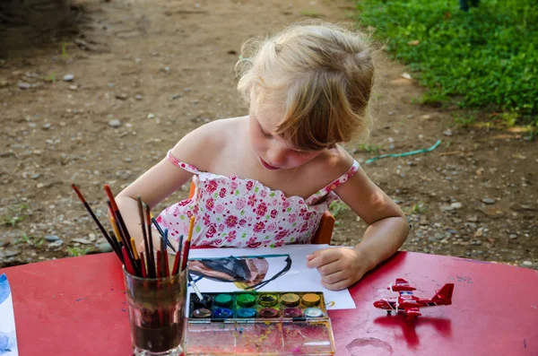 Beautiful blond girl painting — Stock Photo, Image