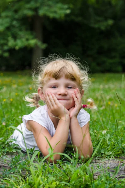 Blond girl on grass Royalty Free Stock Images
