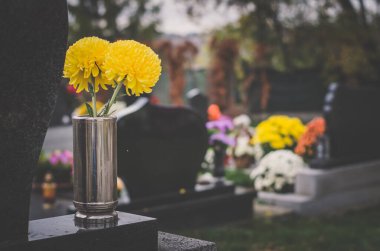 Mezarlıkta tüm azizler gününde mezarlar, çiçekler, dekorasyon ve mumlar, cenaze konsepti