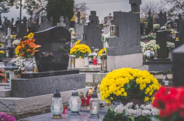 Mezarlıkta tüm azizler gününde mezarlar, çiçekler, dekorasyon ve mumlar, cenaze konsepti