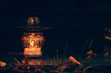 Mezarlıkta Azizler Günü 'nde fenerde mum yakmak.