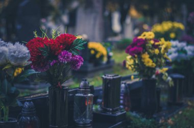 graves with flowers, decorations and candles backgrounds during all saints day on cemetery
