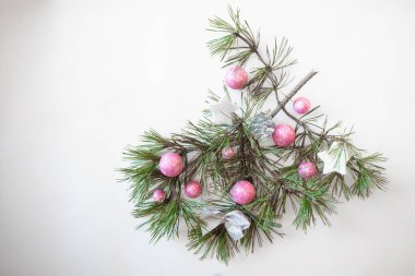 İzole edilmiş noel pembe mücevher ve beyaz arka planda yeşil çam ağacı süslemesi.