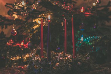 Arka planda ışıklandırılmış noel ağacıyla gelen ilk mumu yakmak