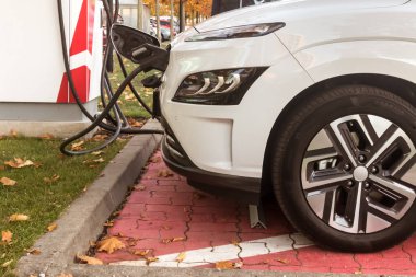 Şarj eden eko yeşil alternatif beyaz renkli elektrikli araç şarj istasyonunda