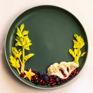 Böğürtlenlerden, salatadan ve karnabahardan oluşan deniz dünyası, tabaklarda izole edilmiş renkli gıda fikirleri, kopyalama alanı