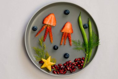 Çilek, böğürtlen, fasulye ve nar gibi tenha renkli gıda fikirlerinden denizanası, yeşil bitkiler ve deniz yıldızları.