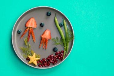 Çilek, böğürtlen, fasulye ve nar gibi tenha renkli gıda fikirlerinden denizanası, yeşil bitkiler ve deniz yıldızları.