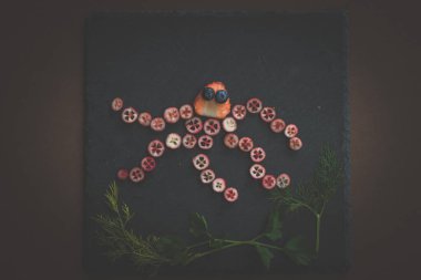 ahtapot siyah zemin üzerinde kırmızı meyvelerden yapılır.