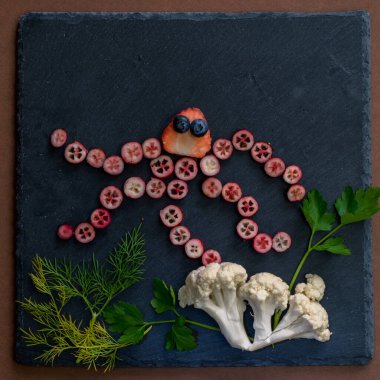 ahtapot siyah zemin üzerinde kırmızı meyvelerden yapılır