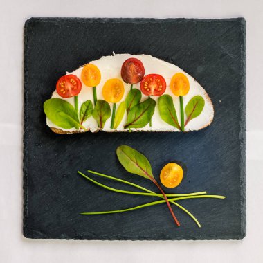 tereyağlı ekmek, kırmızı ve portakallı domates yeşil soğanlı ve fesleğenli çiçekler olarak tasarlandı