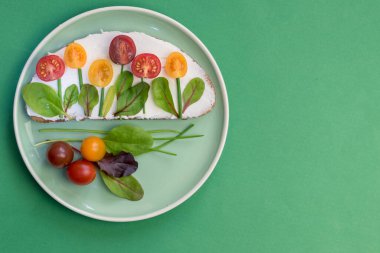 tereyağlı ekmek, kırmızı ve portakallı domates yeşil soğanlı ve fesleğenli çiçekler olarak tasarlandı