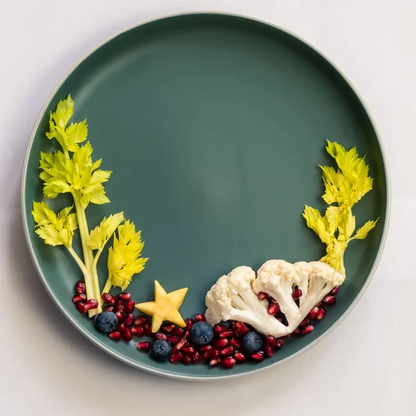 Böğürtlenlerden, salatadan ve karnabahardan oluşan deniz dünyası, tabaklarda izole edilmiş renkli gıda fikirleri, kopyalama alanı