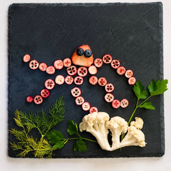 ahtapot siyah zemin üzerinde kırmızı meyvelerden yapılır