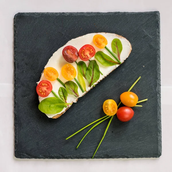 tereyağlı ekmek, kırmızı ve portakallı domates yeşil soğanlı ve fesleğenli çiçekler olarak tasarlandı