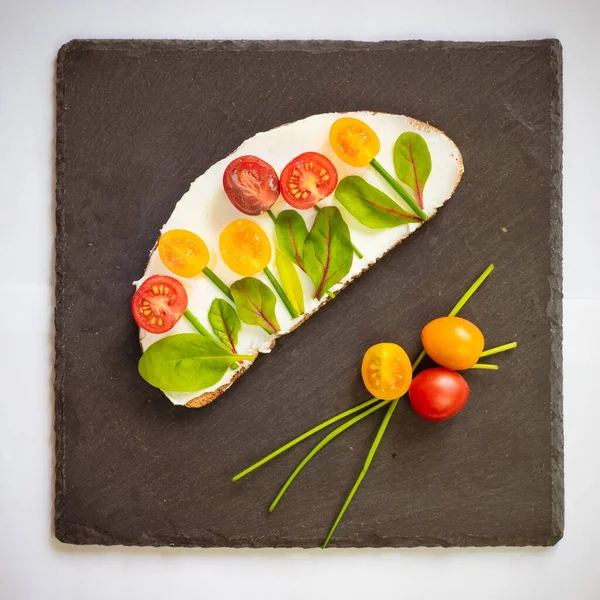 tereyağlı ekmek, kırmızı ve portakallı domates yeşil soğanlı ve fesleğenli çiçekler olarak tasarlandı