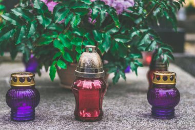 Mezarda yanan mum ve kasımpatı çiçeği dekoru.