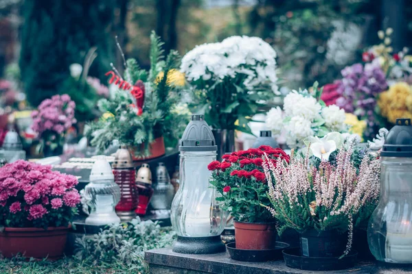 burning candle and chrysanthemum flower decoration on grave in the cemetery