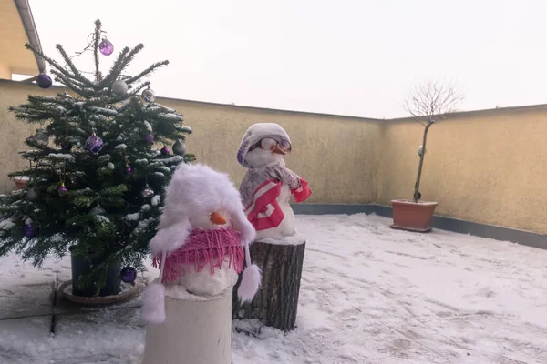 都会の雪のテラスで雪だるまと遊ぶ少女 — ストック写真