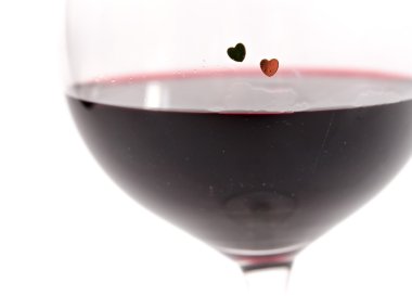 beyaz zemin üzerine kırmızı şarap ile bir cam üzerinde iki kalp