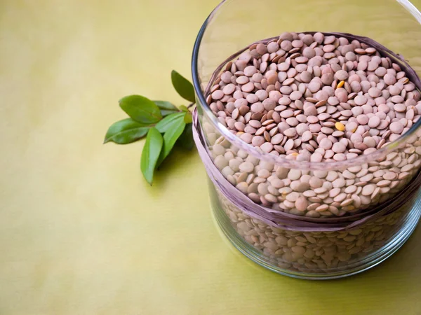Lentil in glass jar on green background — Stock Photo, Image