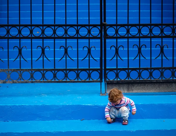 Little girl playing with herself on blue stairs — Stock Photo, Image
