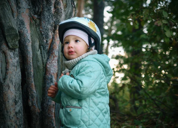 Serious little kid in a helmet looking up — Stock Photo, Image