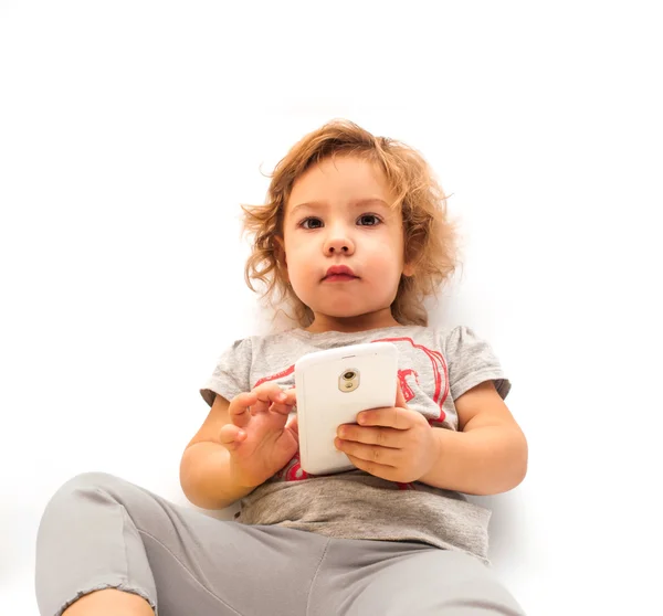 Девочка играет со смартфоном — стоковое фото
