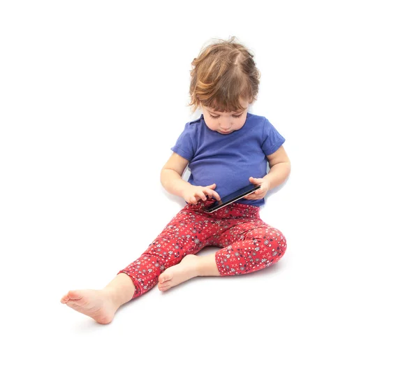 Little kid sitting and playing smartphone — Stock Photo, Image