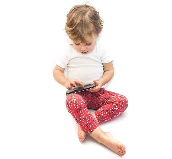 Little kid playing with smatphone on white background — Stock Photo, Image